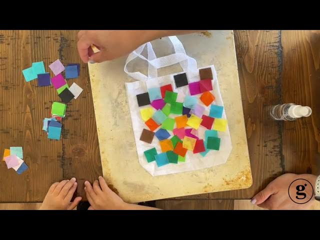 image: small white tote bag covered in small squares of colored tissue paper to make a tie dye effect